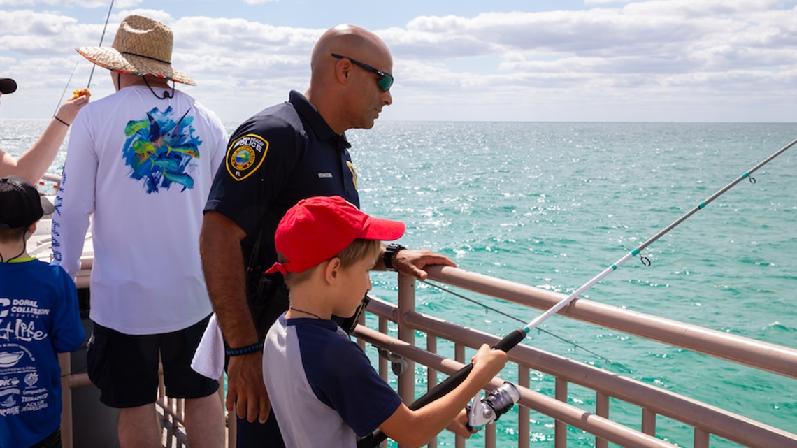 Cop fishing with young kid.